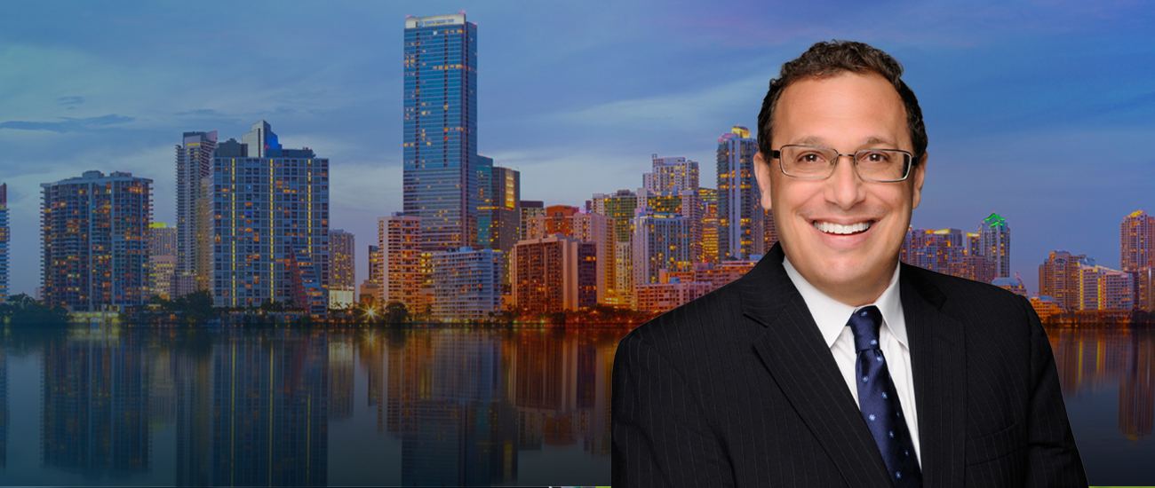Attorney David H. Pollack in front of a city skyline at sunset